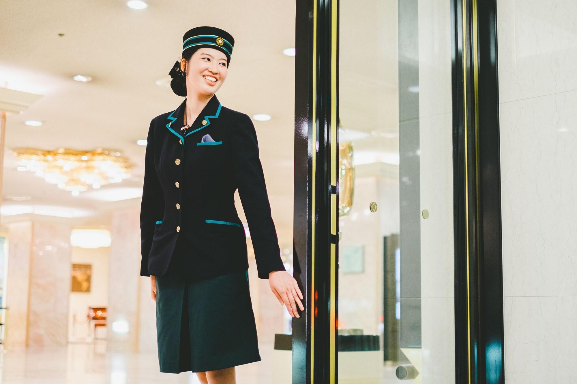 Hotel New Otani Hakata Fukuoka  Buitenkant foto A female doorman at the entrance of a hotel